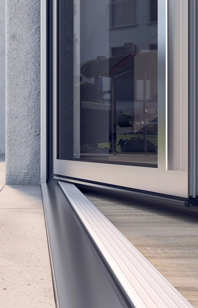 Close-up of a sliding glass door with a metal frame, track, and exterior wall tiles outside the entrance.
